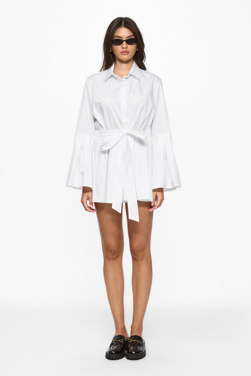 Woman wearing a white shirt dress on a white background