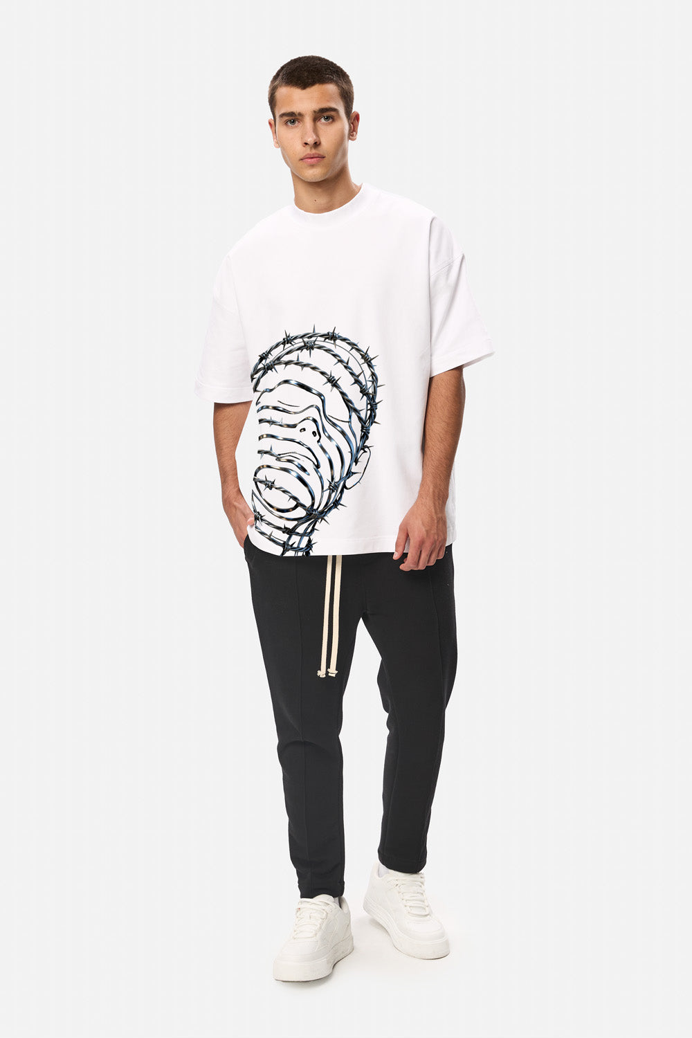 Vedere full-body din față a unui model purtând tricoul oversized alb Barbed Wire Head pentru bărbați, cu imprimeu din sârmă ghimpată