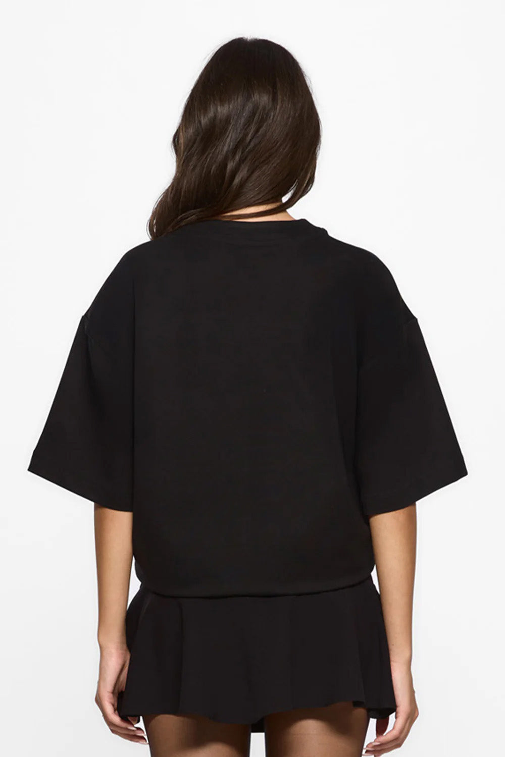 Vedere din spate a unui model purtând tricoul oversized negru Polka Dots Corset pentru femei