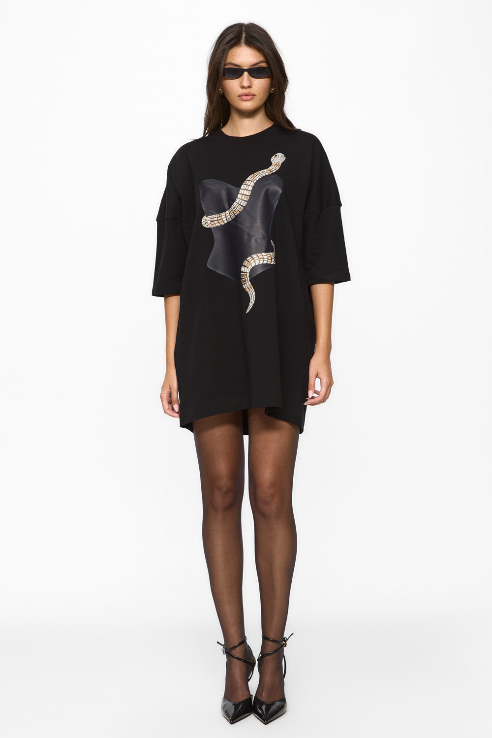 Woman wearing a black dress with a snake design on a white background