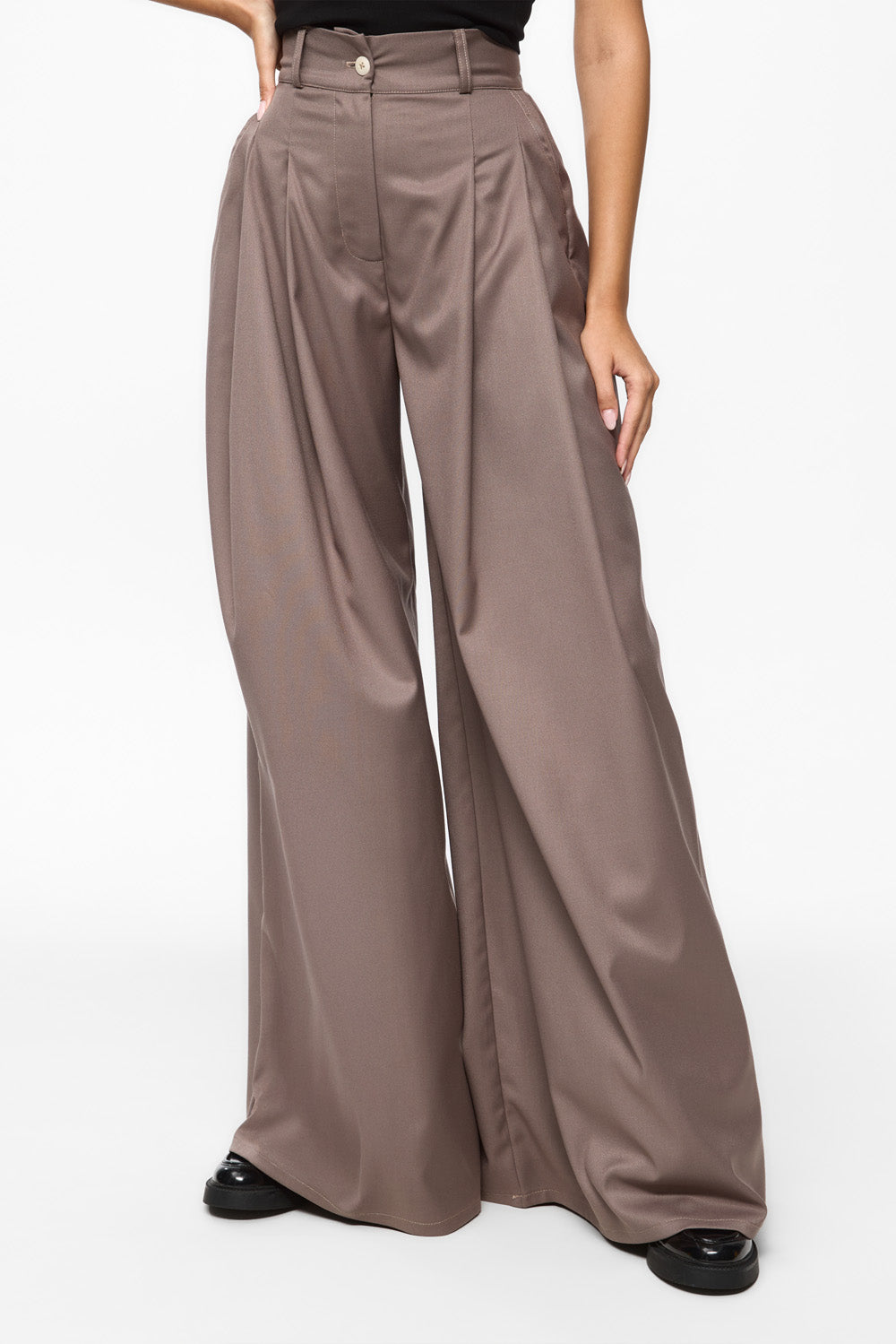 Brown wide-leg pants worn by a person on a white background