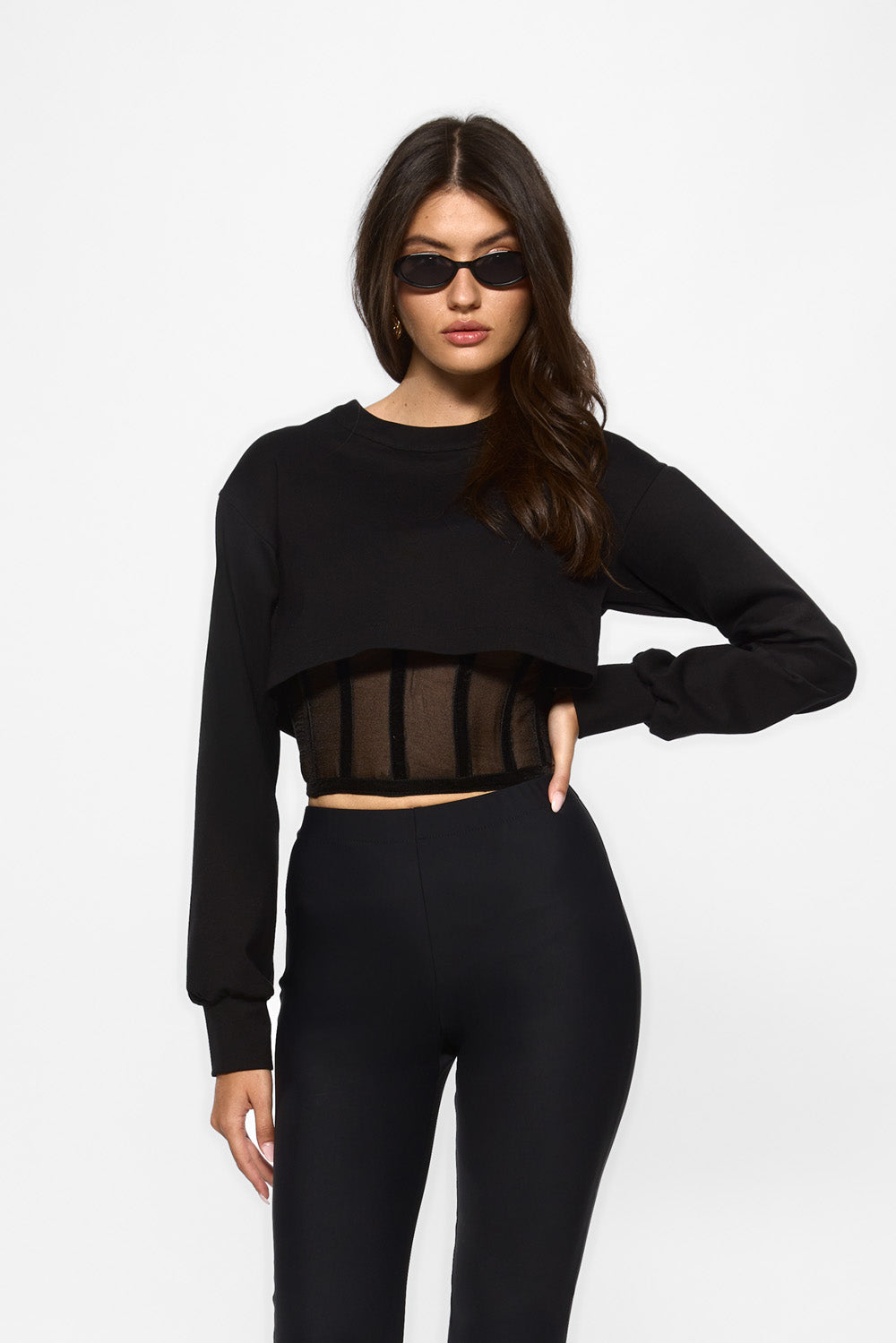 Woman wearing a black outfit with sheer mesh panels by hamza. Organza top for women