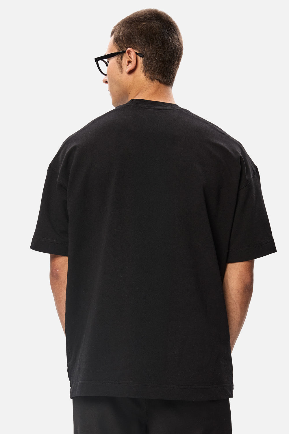 Model purtând tricoul oversized negru Don’t Call Me Lucky pentru bărbați, vedere din spate, evidențiind croiala oversized și spatele simplu