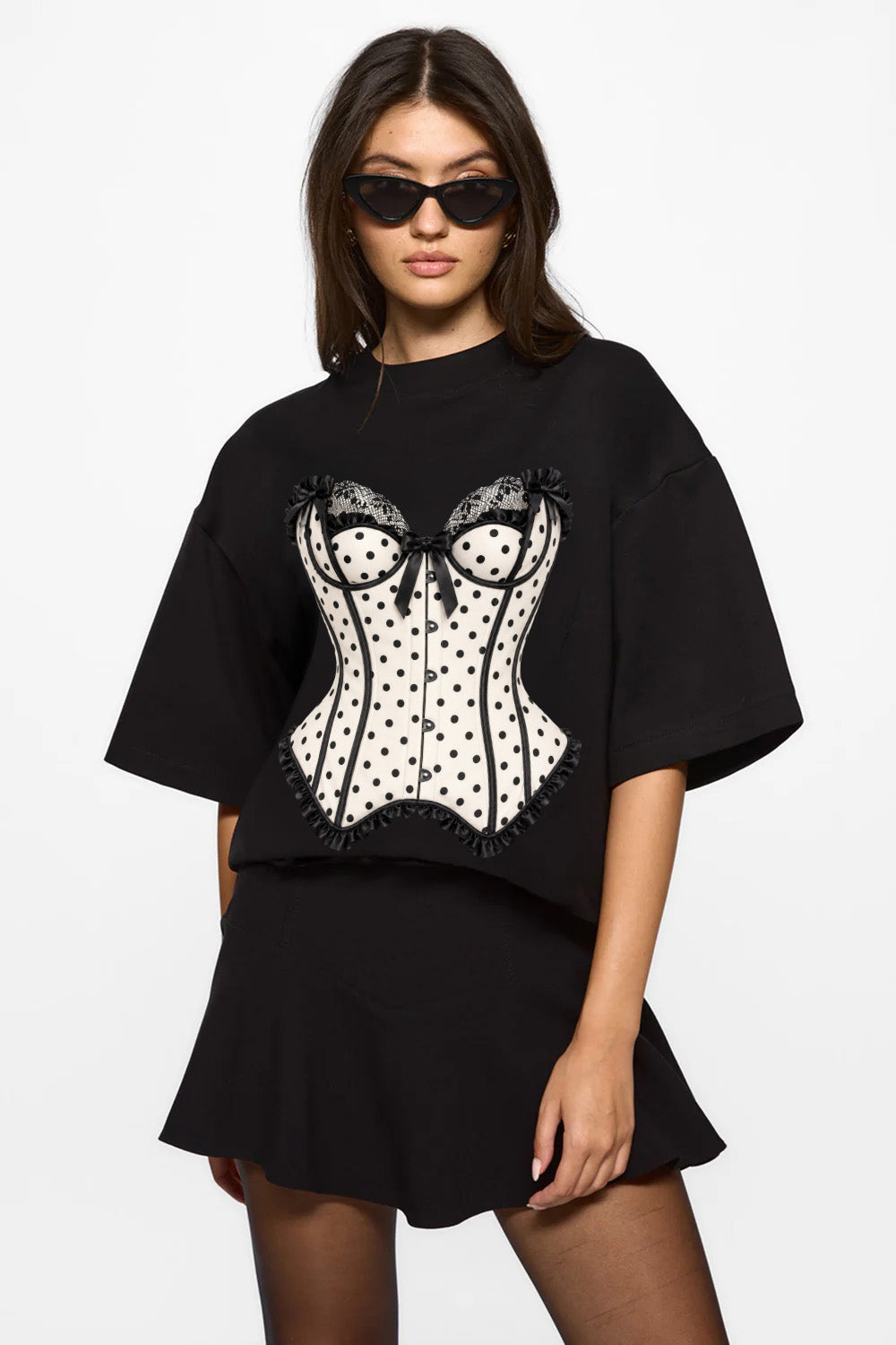 Vedere frontală din trei sferturi a unui model purtând tricoul negru Polka Dots Corset, cu imprimeu statement pe față